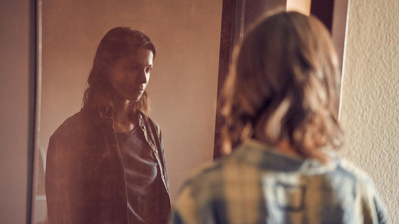 Szene aus der Serie "Unbroken". Alex (Aylin Tezel) steht mit leinem leeren Blick vor einem Spiegel. Szene aus der Serie "Unbroken". Alex (Aylin Tezel) steht mit leinem leeren Blick vor einem Spiegel.