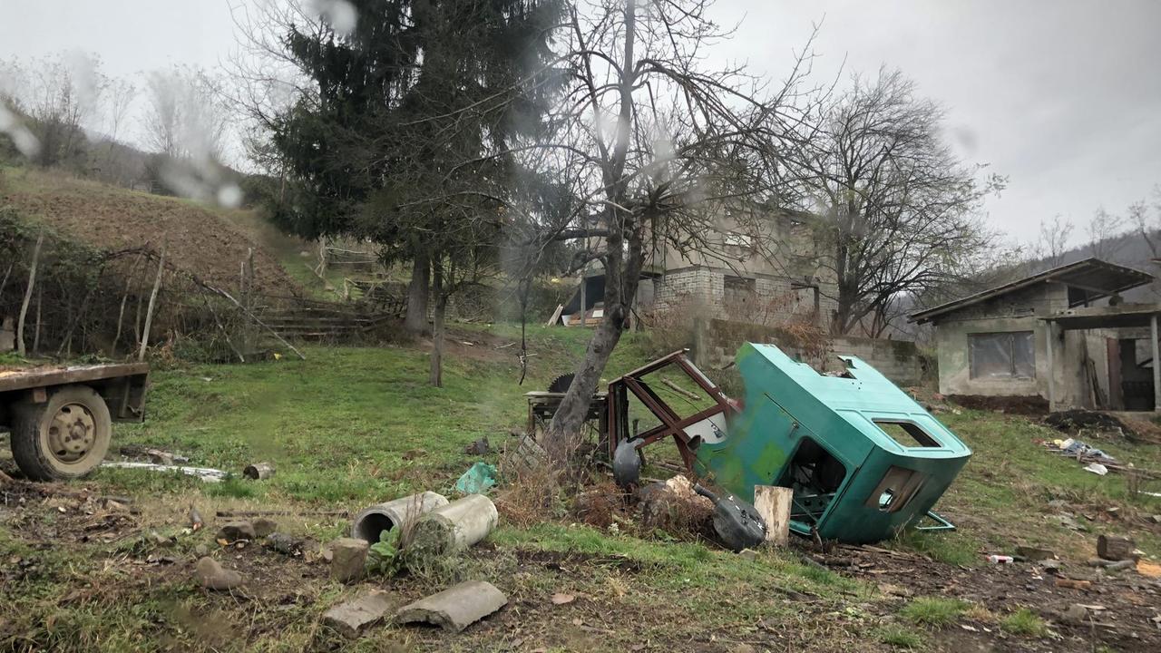 Ein Autowrack inmitten eines Dorfes Ein Autowrack inmitten eines Dorfes