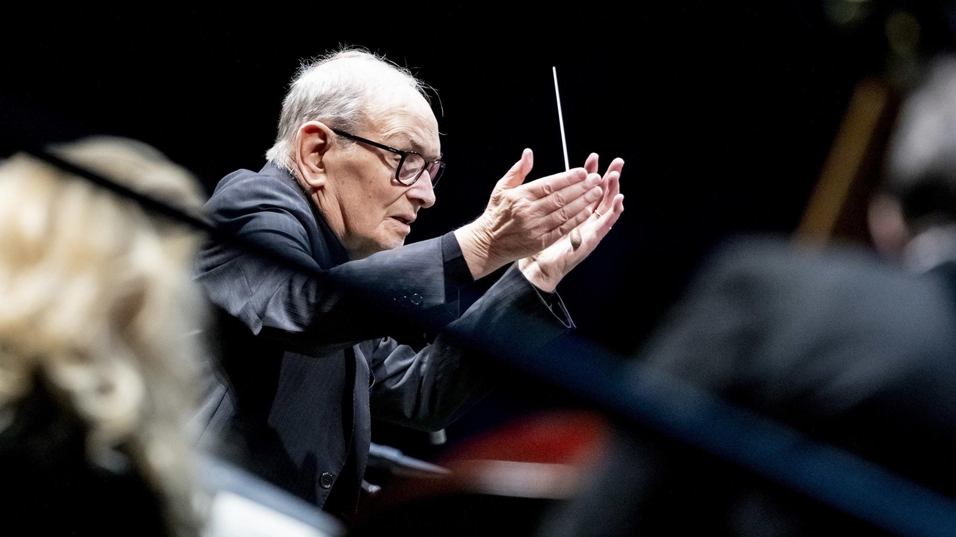 Der Komponist Ennio Morricone bei seiner "The Farewell Tour" mit Taktstock in der Hand. Der Komponist Ennio Morricone bei seiner "The Farewell Tour" mit Taktstock in der Hand.