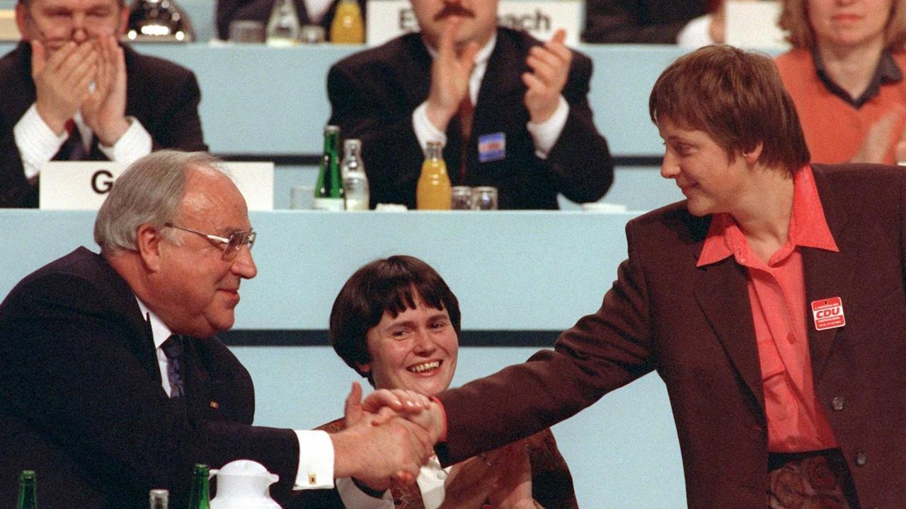 Christine Lieberknecht (Mitte) neben dem damaligen Bundeskanzler Helmut Kohl, der seiner neugewählten Stellvertreterin, der damaligen Frauenministerin Angela Merkel während des Parteitags der CDU am 15. Dezember 1991 im Kulturpalast in Dresden per Handschlag gratuliert. Christine Lieberknecht (Mitte) neben dem damaligen Bundeskanzler Helmut Kohl, der seiner neugewählten Stellvertreterin, der damaligen Frauenministerin Angela Merkel während des Parteitags der CDU am 15. Dezember 1991 im Kulturpalast in Dresden per Handschlag gratuliert.