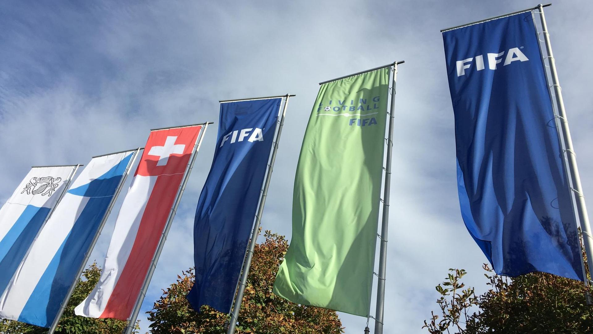 Fahnen der FIFA und der Schweiz wehen im Wind.