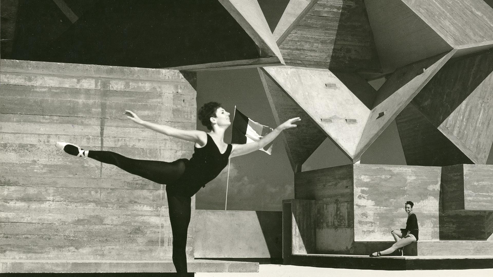 Schwarz-Weiß-Foto des Rathauses von Bat Yam in Israel, davor eine Ballettänzerin, die auf einem Bein balanciert. Schwarz-Weiß-Foto des Rathauses von Bat Yam in Israel, davor eine Ballettänzerin, die auf einem Bein balanciert.