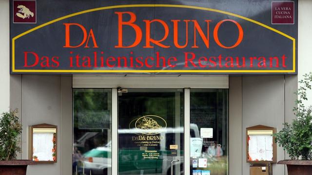 Ein Polizeiwagen spiegelt sich am Mittwoch (15.08.2007) in Duisburg in der Eingangstür des Restaurants "Da Bruno" in der Nähe des Tatortes