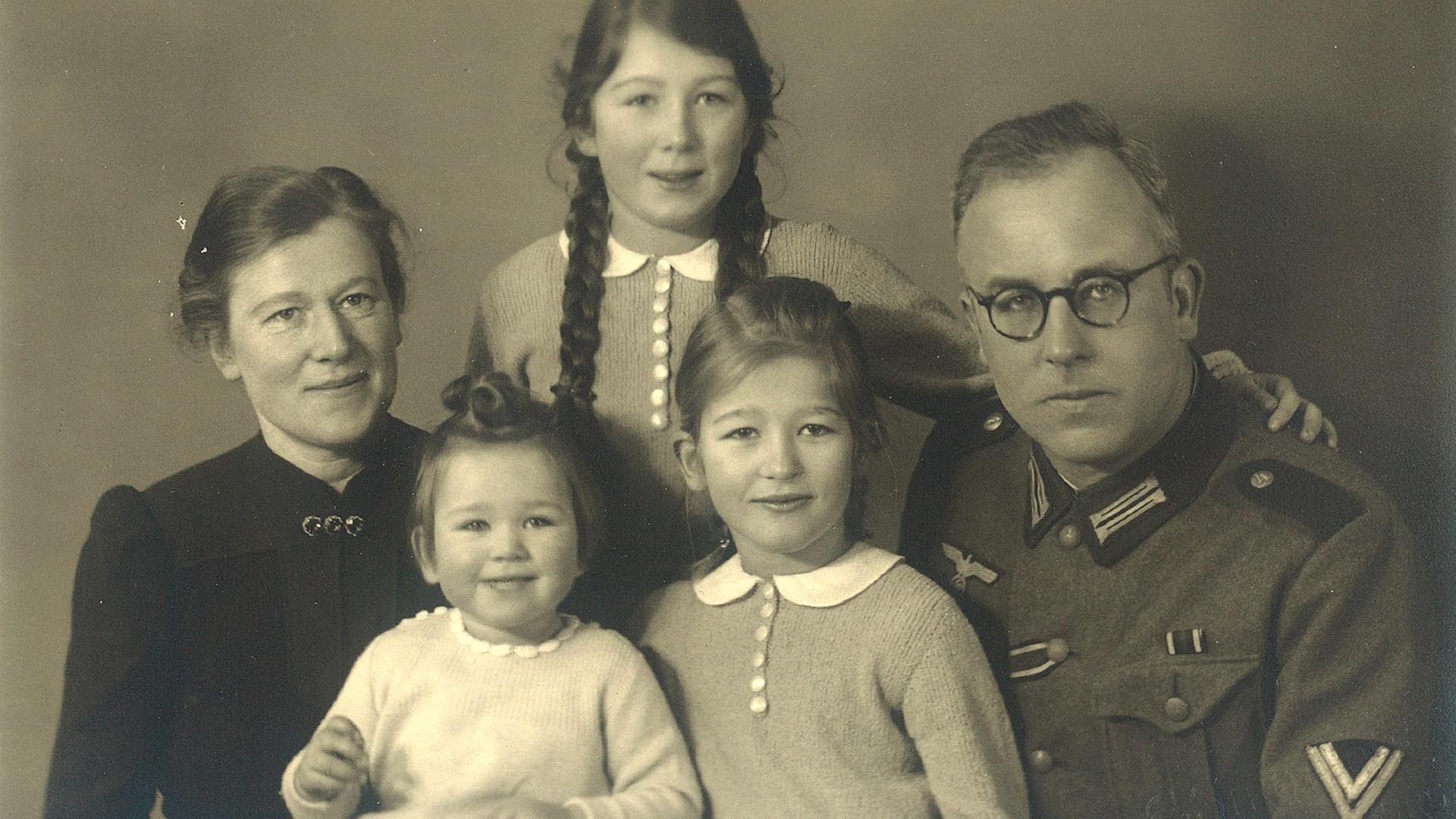Schwarzweißes Familienfoto. Ein Mann in Uniform mit seiner Frau und drei Kindern. Schwarzweißes Familienfoto. Ein Mann in Uniform mit seiner Frau und drei Kindern.