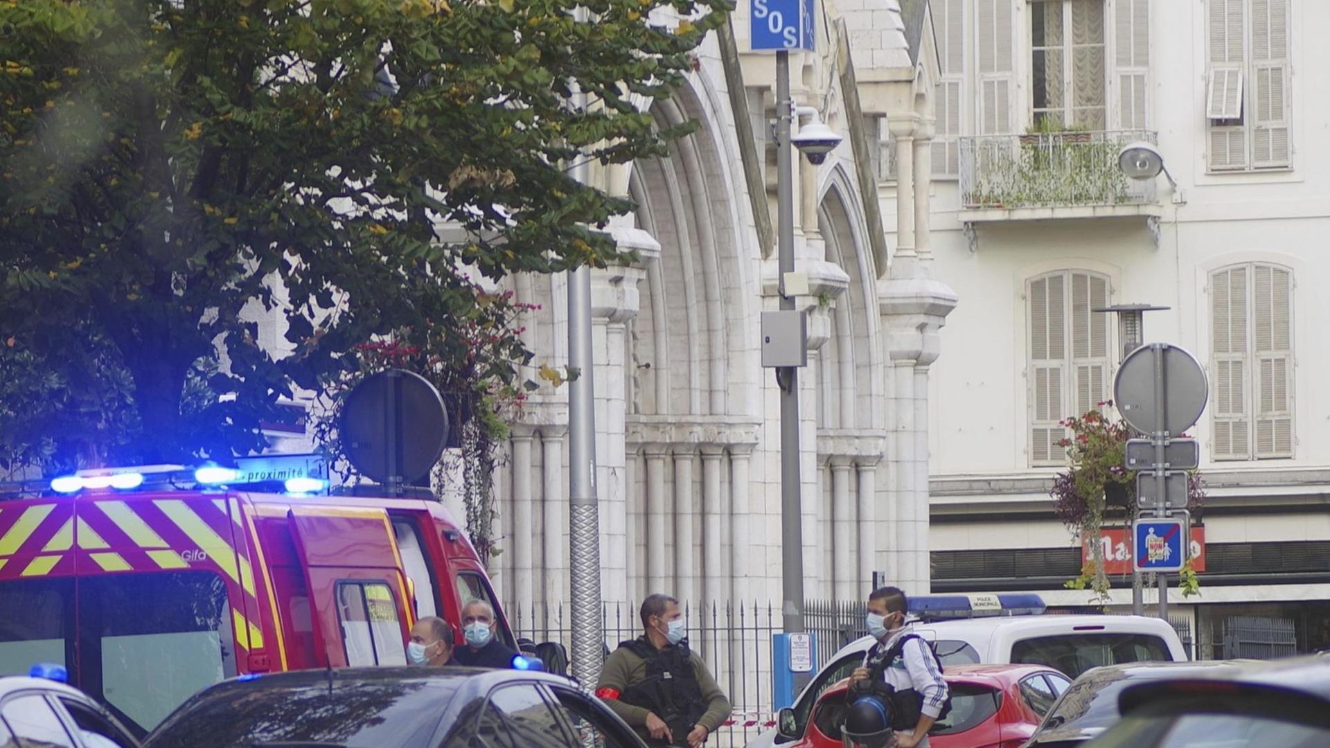 Polizisten und ein Krankenwagen stehen vor einer Kirche in Nizza. Polizisten und ein Krankenwagen stehen vor einer Kirche in Nizza.
