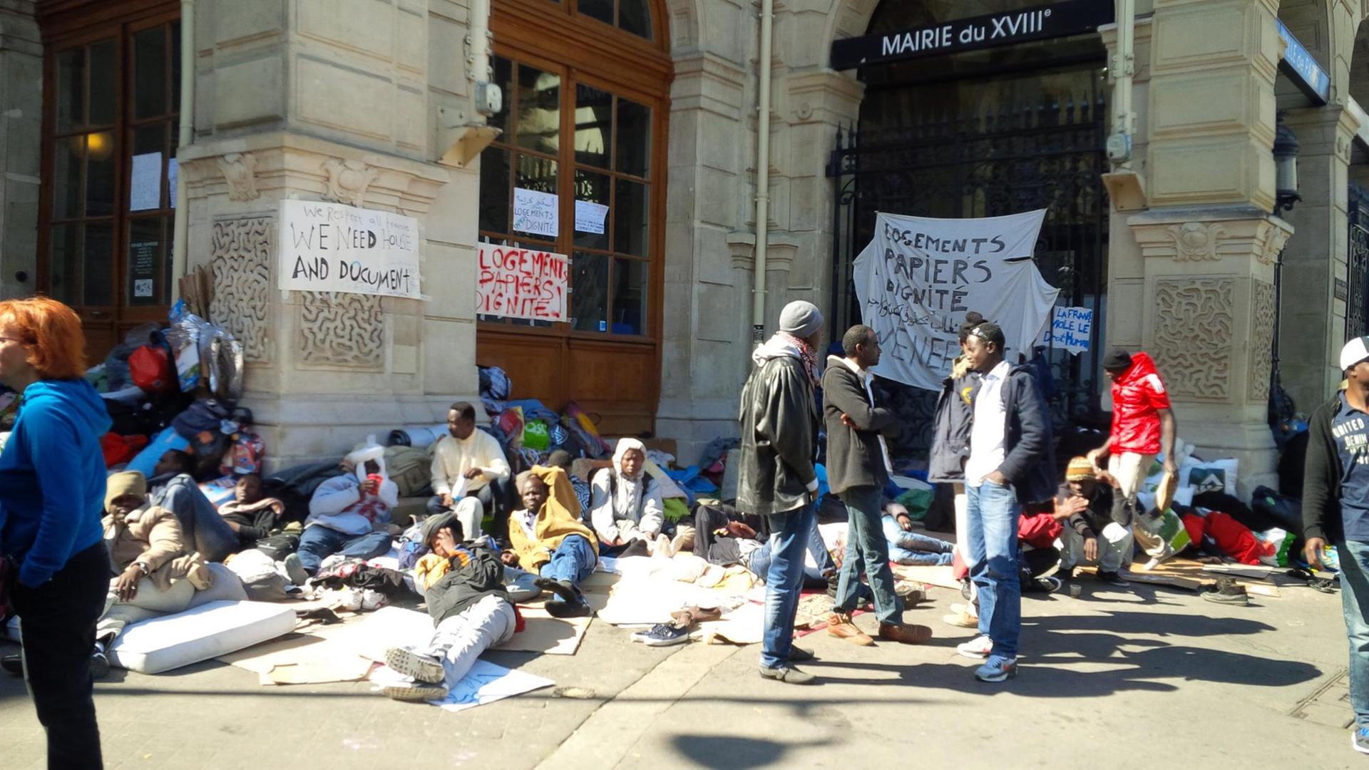 Flüchtlinge stehen, sitzen und liegen vor dem Verwaltungsgebäude des 18. Arondissements in Paris. Flüchtlinge stehen, sitzen und liegen vor dem Verwaltungsgebäude des 18. Arondissements in Paris.
