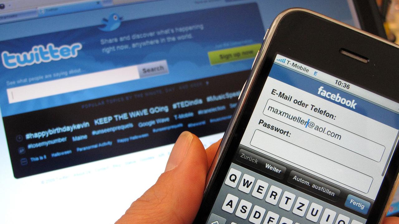Facebook-Anmeldemaske auf einem Smartphone, während auf dem Bildschirm im Hintergrund die Startseite für den Kurznachrichtendienst Twitter zu sehen ist. Facebook-Anmeldemaske auf einem Smartphone, während auf dem Bildschirm im Hintergrund die Startseite für den Kurznachrichtendienst Twitter zu sehen ist.