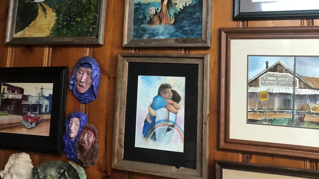 Bilderwand im Coney Island Café - Eines der Bilder zeigt den Vater des Besitzers Billy Fokakis, wie er Jesus umarmt