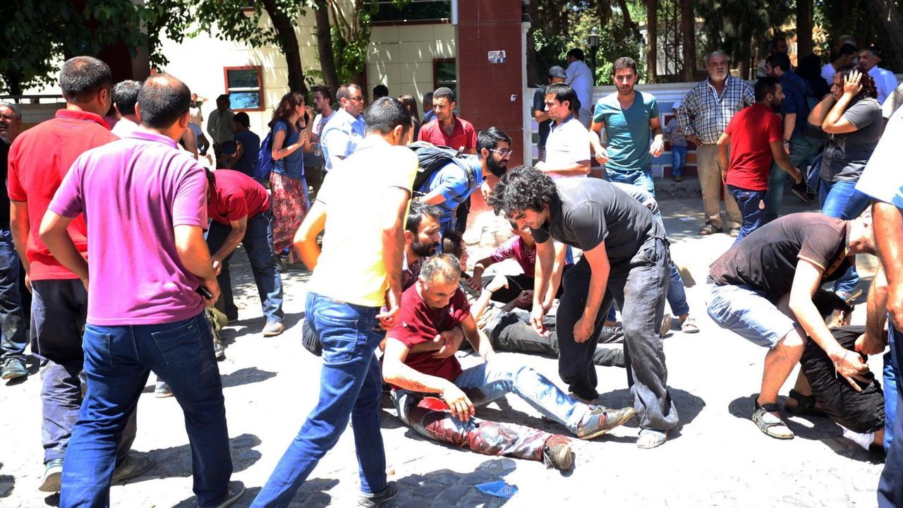 Helfer versuchen im Garten des Kulturzentrums von Suruc, Verletzten zu helfen.