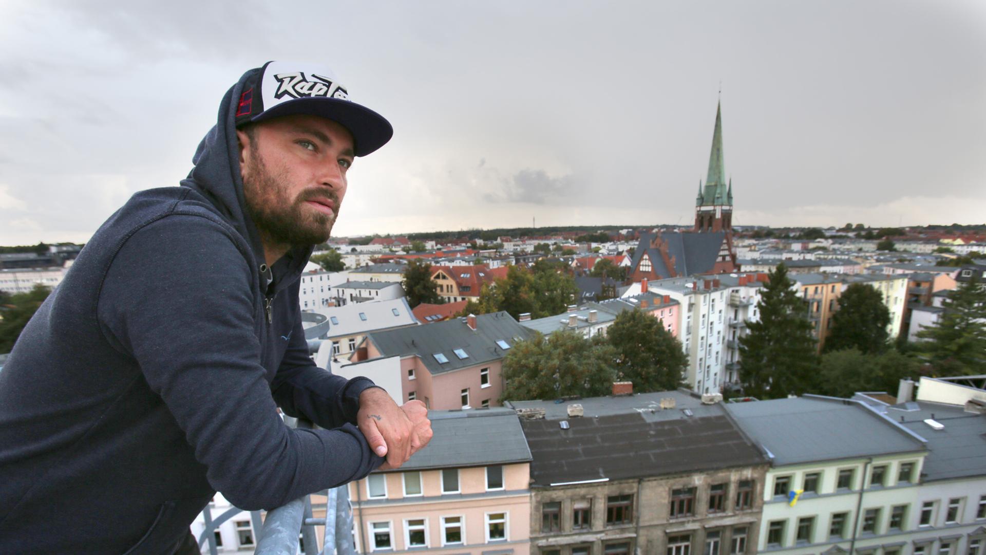Der Rapper Marteria steht auf dem Dach der Brauerei in Rostock vor der Silhouette der Kröpeliner Tor Vorstadt Der Rapper Marteria steht auf dem Dach der Brauerei in Rostock vor der Silhouette der Kröpeliner Tor Vorstadt