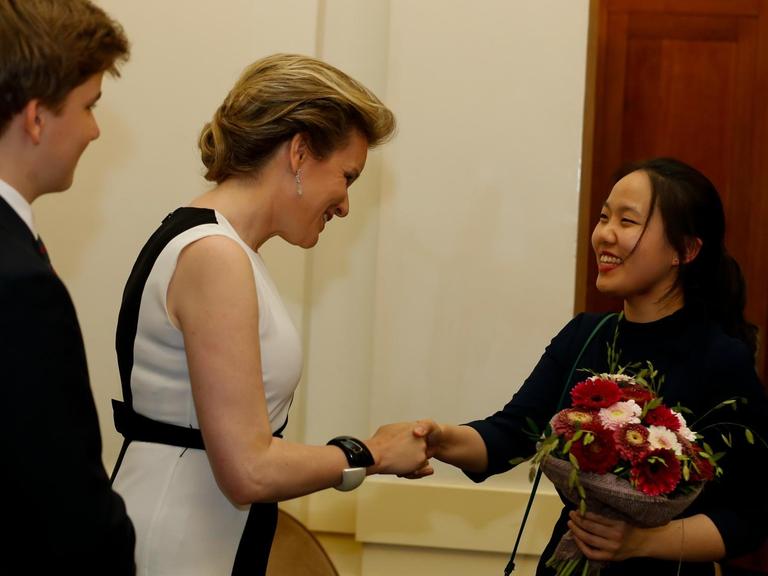 25.05.2019, Belgien, Brüssel: Königin Mathilde von Belgien gratuliert der Geigerin Stella Chen. Sie hat den "Königin Elisabeth Wettbewerb" gewonnen.