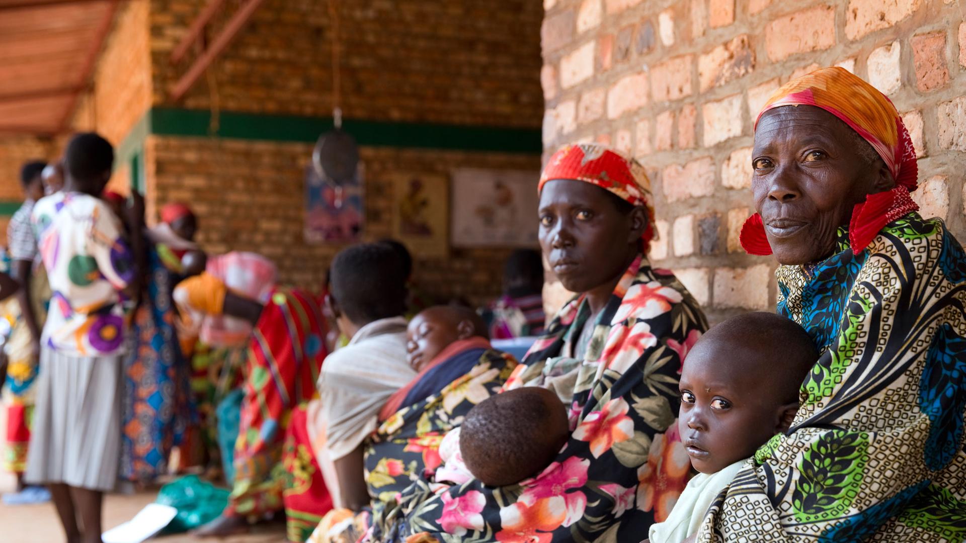 Eltern mit ihren Kindern in einer Gesundheitsstation im Dorf Rukogo im Norden von Burundi Eltern mit ihren Kindern in einer Gesundheitsstation im Dorf Rukogo im Norden von Burundi