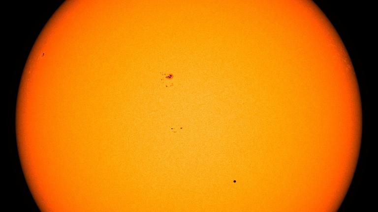 Merkur erscheint beim Transit vor der Sonne als kleiner schwarzer Punkt – weiter oben sind einige Sonnenflecken zu erkennen Merkur erscheint beim Transit vor der Sonne als kleiner schwarzer Punkt – weiter oben sind einige Sonnenflecken zu erkennen