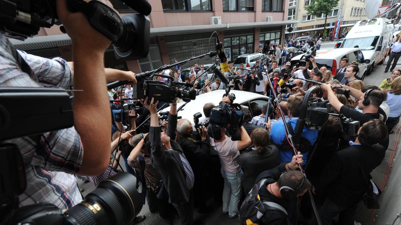 Umlagert von Medienvertretern steigt Verteidiger Johann Schwenn (verdeckt) in ein Auto nach dem Freispruch für seinen Mandanten Jörg Kachelmann am Dienstag (31.05.2011) vor dem Landgericht in Mannheim. 