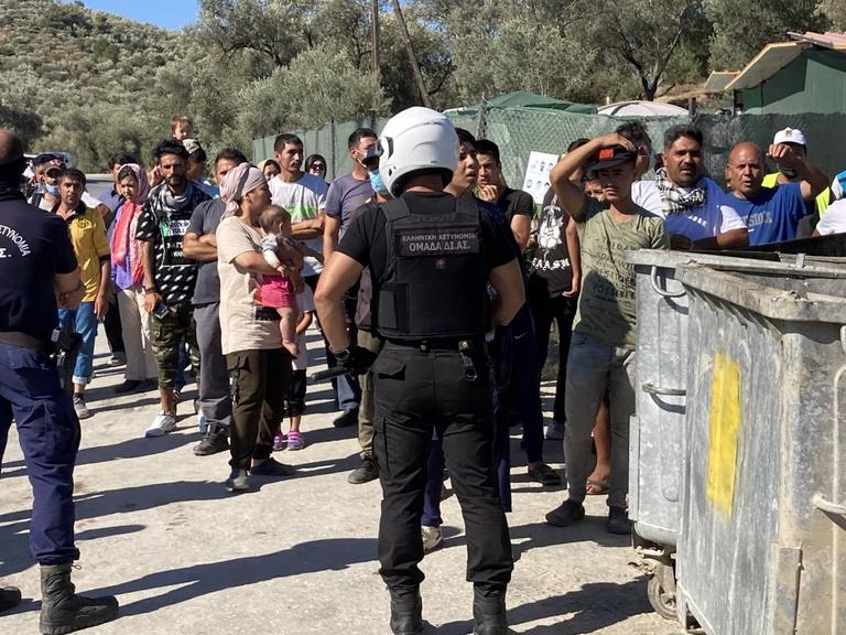 Sicherheitskräfte schirmen bei einem Besuch von Nordrhein-Westfalens Ministerpräsident Laschet und Integrationsminister Stamp im Flüchtlingslager Moria Flüchtlinge ab
