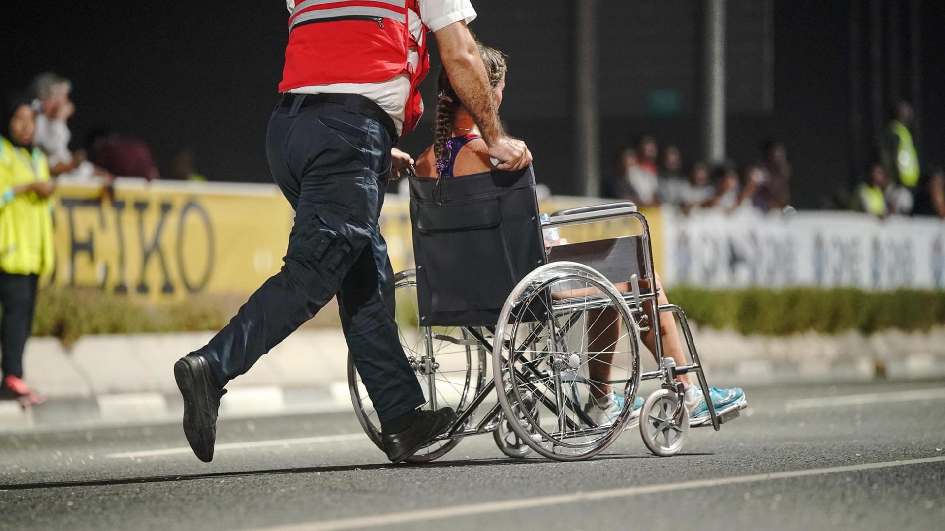 Eine erschöpfte Marathon-Läuferin im Rollstuhl bei der Leichtathletik-WM in Doha. Eine erschöpfte Marathon-Läuferin im Rollstuhl bei der Leichtathletik-WM in Doha.