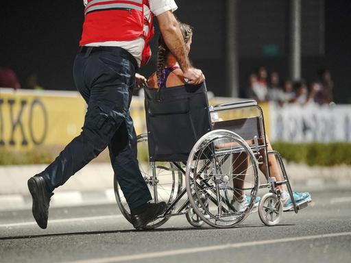 Eine erschöpfte Marathon-Läuferin im Rollstuhl bei der Leichtathletik-WM in Doha.