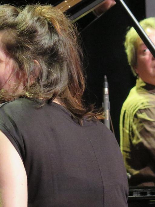Eve Risser sitzt hinter einem Flügel und schaut lachend zur Seite, der Kontrabassist Benjamin Duboc spielt im Hintergrund. Jazzdor Festival 2019 in Berlin