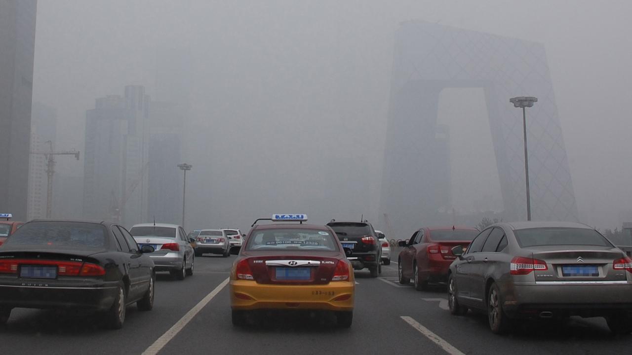Starker Verkehr in Peking, die Stadt liegt unter dichtem Smog Starker Verkehr in Peking, die Stadt liegt unter dichtem Smog