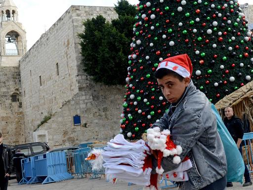 Ein palästinensischer Junge verkauft Weihnachtsmützen auf dem Manger Platz vor der Geburtskirche Jesu in Bethlehem.