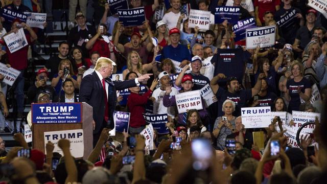 Donald Trump steht bei einer Wahlkampfveranstaltung in New Mexico am 24. Mai 2016 am Rednerpult, umringt von Anhängern, die Schilder mit Trump-Slogans in die Höhe halten.