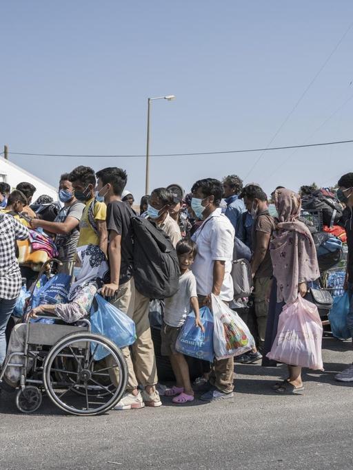 Die Flüchtlinge aus Moria haben sich mit ihren wenigen Habseligkeiten zum Checkpoint begeben um ins neue Lager aufgenommen zu werden. Das neue Zeltlager wird von der griechischen Armee auf einem Militärgelände an der Küste aufgebaut, vor dem Einlass ist Checkpoint mit Polizeikontrolle eingerichtet.