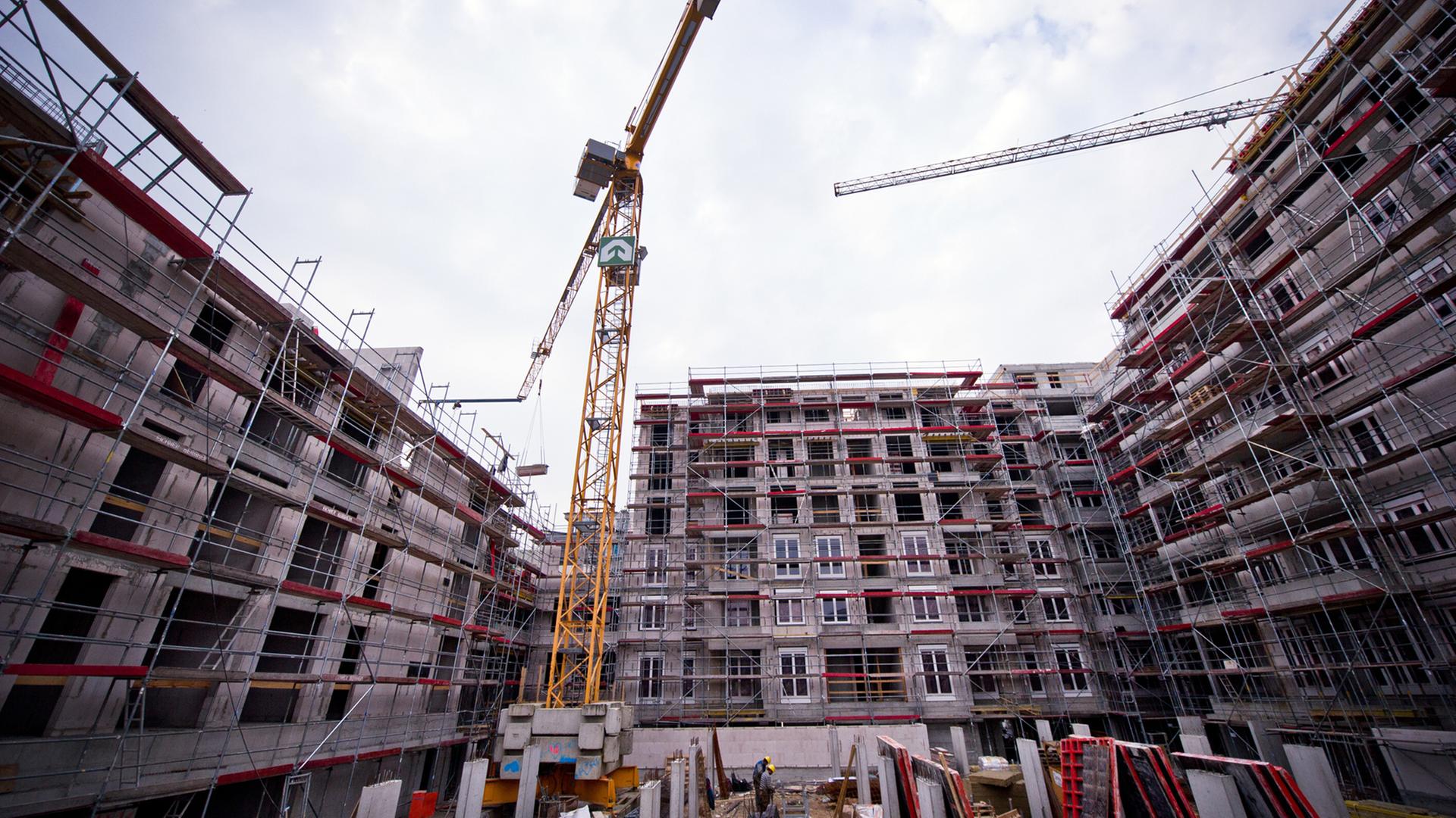 Auf der Baustelle eines Wohnungsneubaus im Jahr 2014 in Berlin sind Rohbauten und Kräne zu sehen. Auf der Baustelle eines Wohnungsneubaus im Jahr 2014 in Berlin sind Rohbauten und Kräne zu sehen.