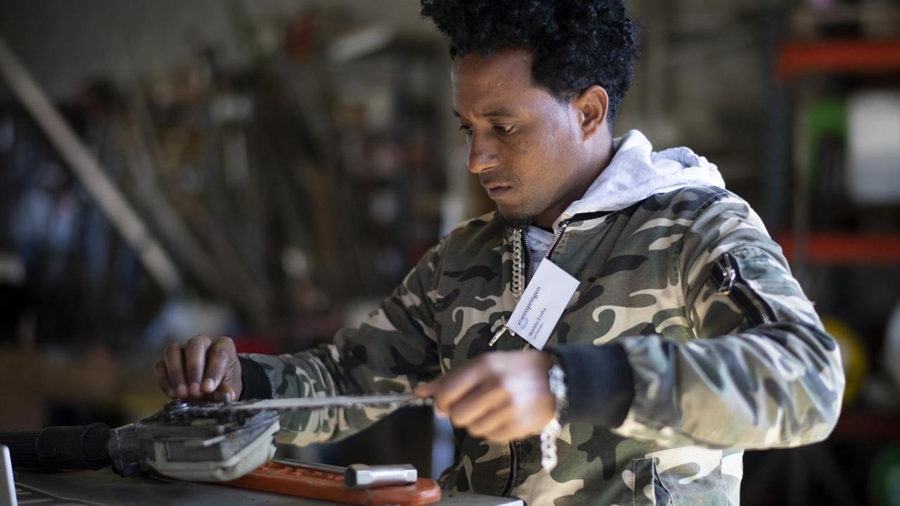Weldu Emha aus Eritrea, Teilnehmer eines Qualifizierungsprogramm für Flüchtlinge, bei der Werkzeugpflege.