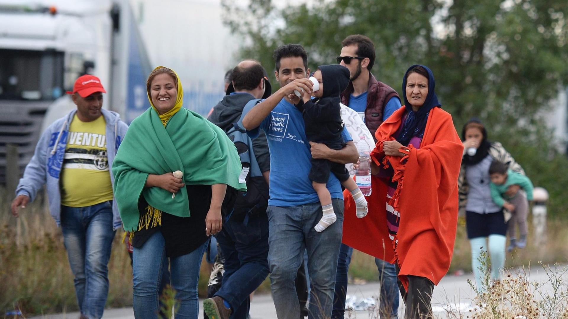Erschöpft und erleichtert: Flüchtlinge, die die ungarisch-österreichische Grenze passieren. Erschöpft und erleichtert: Flüchtlinge, die die ungarisch-österreichische Grenze passieren.