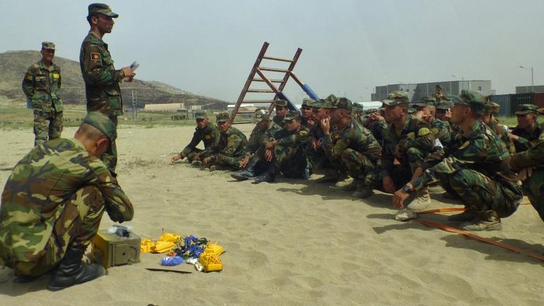 Afghanische Soldaten hocken vor Plastikspielzeug im Sand. Afghanische Soldaten hocken vor Plastikspielzeug im Sand.