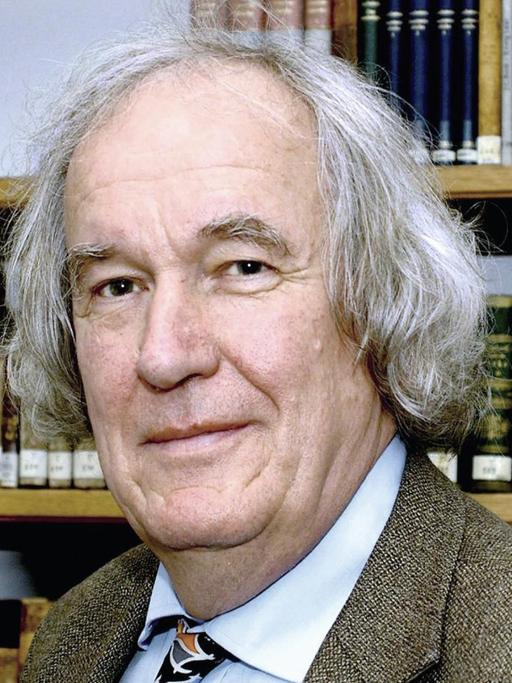 POrtrait Dieter Borchmeyer vor einem Bücherregal, in Jacket, weißem Hemd und Krawatte