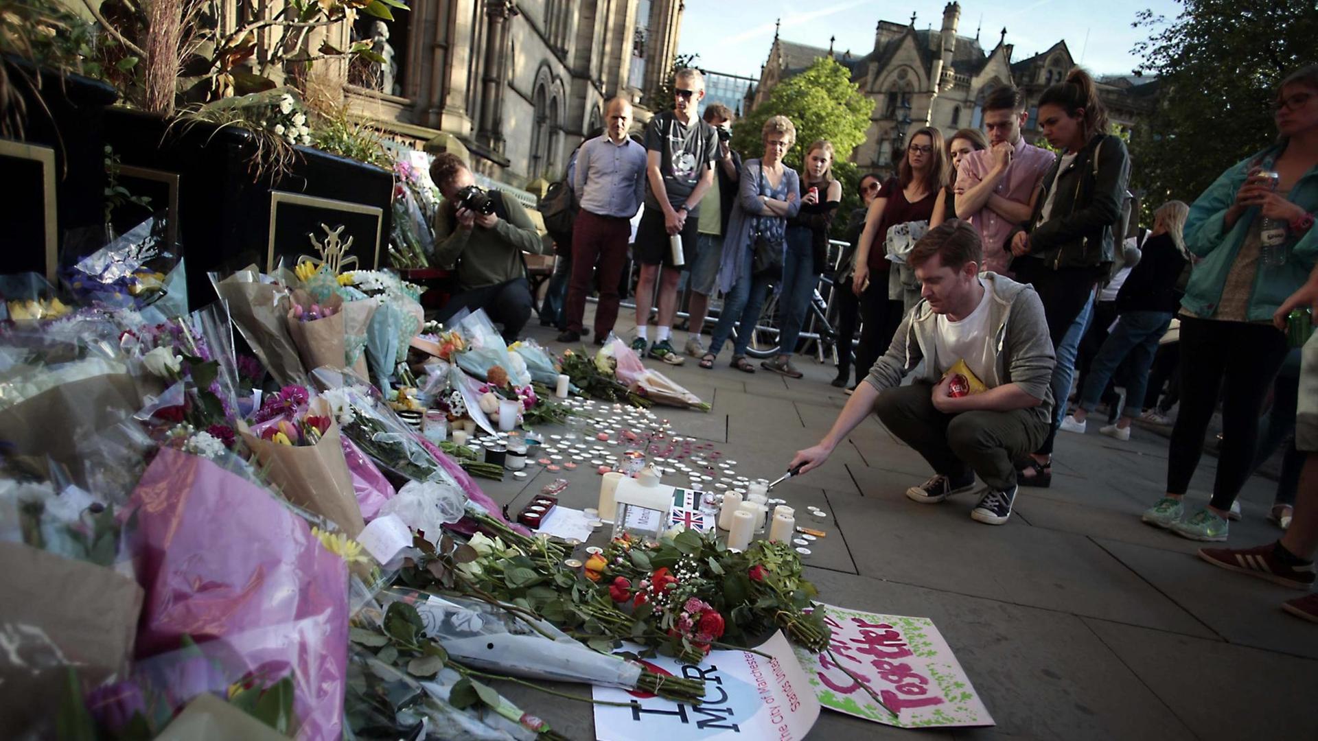 Menschen zünden Kerzen für die Opfer des Attentates in Manchester an. Menschen zünden Kerzen für die Opfer des Attentates in Manchester an.