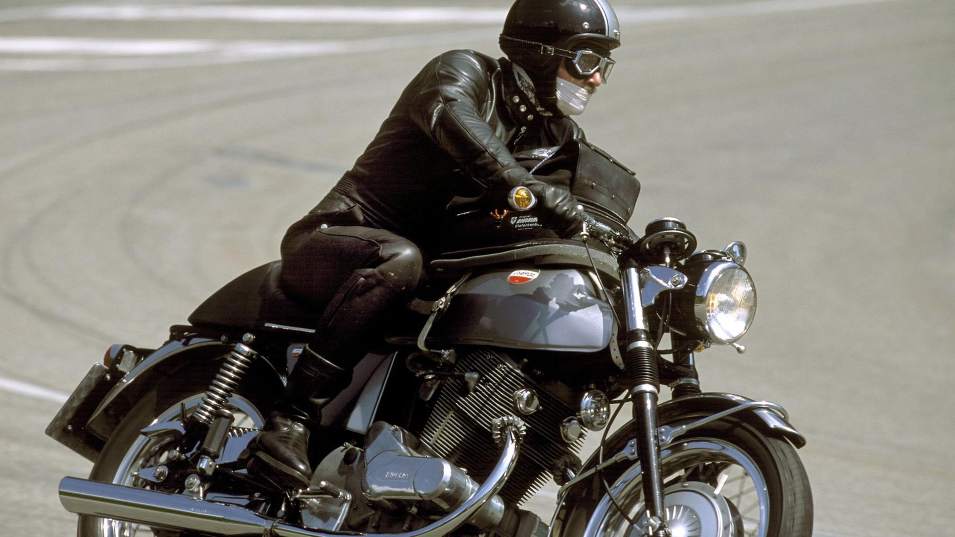 Auf dem Bild sieht man einen Motorradfahrer, der am Großen Feldberg in eine Kurve fährt. Das Motorrad ist eine restaurierte Laverda. Auf dem Bild sieht man einen Motorradfahrer, der am Großen Feldberg in eine Kurve fährt. Das Motorrad ist eine restaurierte Laverda.