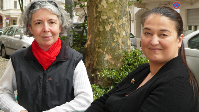 Gülcan Nitsch und Özlem Yildiz sitzen an einer Straße Gülcan Nitsch und Özlem Yildiz sitzen an einer Straße