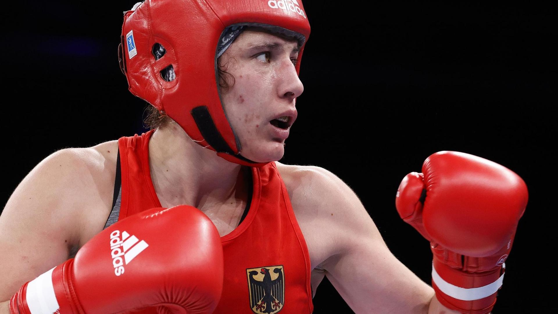Amateurboxerin Sarah Scheurichni roter Sportkleidung im Ring, sie hält die Hände in Boxhandschuhen erhoben Amateurboxerin Sarah Scheurichni roter Sportkleidung im Ring, sie hält die Hände in Boxhandschuhen erhoben