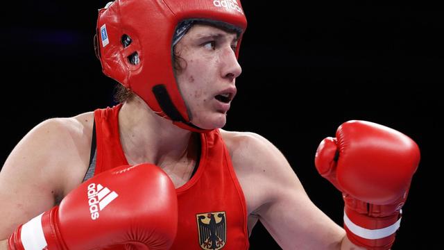 Amateurboxerin Sarah Scheurichni roter Sportkleidung im Ring, sie hält die Hände in Boxhandschuhen erhoben
