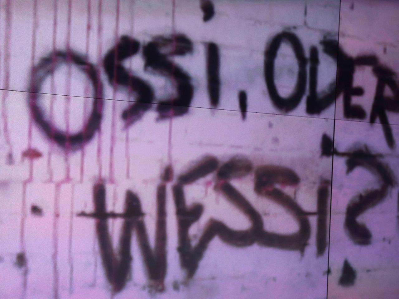 Ossi oder Wessi, fragt ein Graffito an der Wand. Auch 28 Jahre nach der Wiedervereinigung existieren diese Kategorien. Ossi oder Wessi, fragt ein Graffito an der Wand. Auch 28 Jahre nach der Wiedervereinigung existieren diese Kategorien.