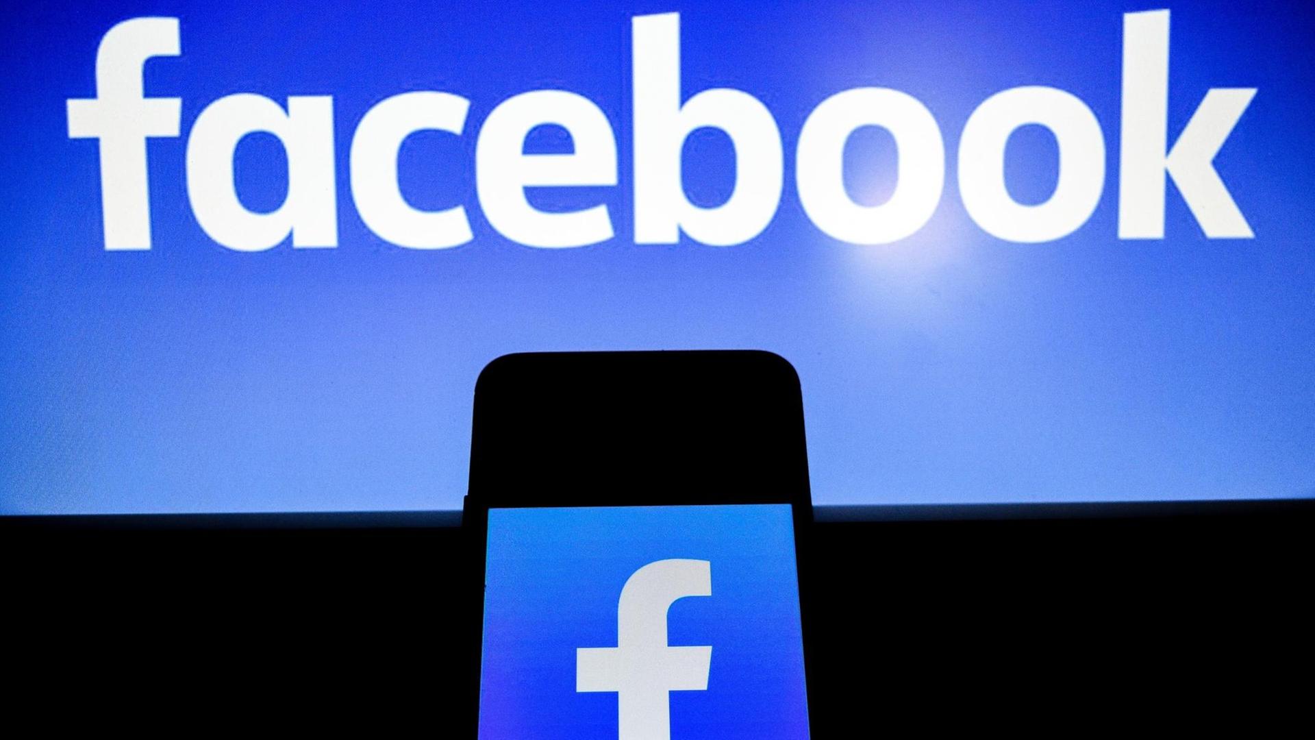 Das Foto zeigt ein Telefon und das Logo von Facebook. Das Foto zeigt ein Telefon und das Logo von Facebook.