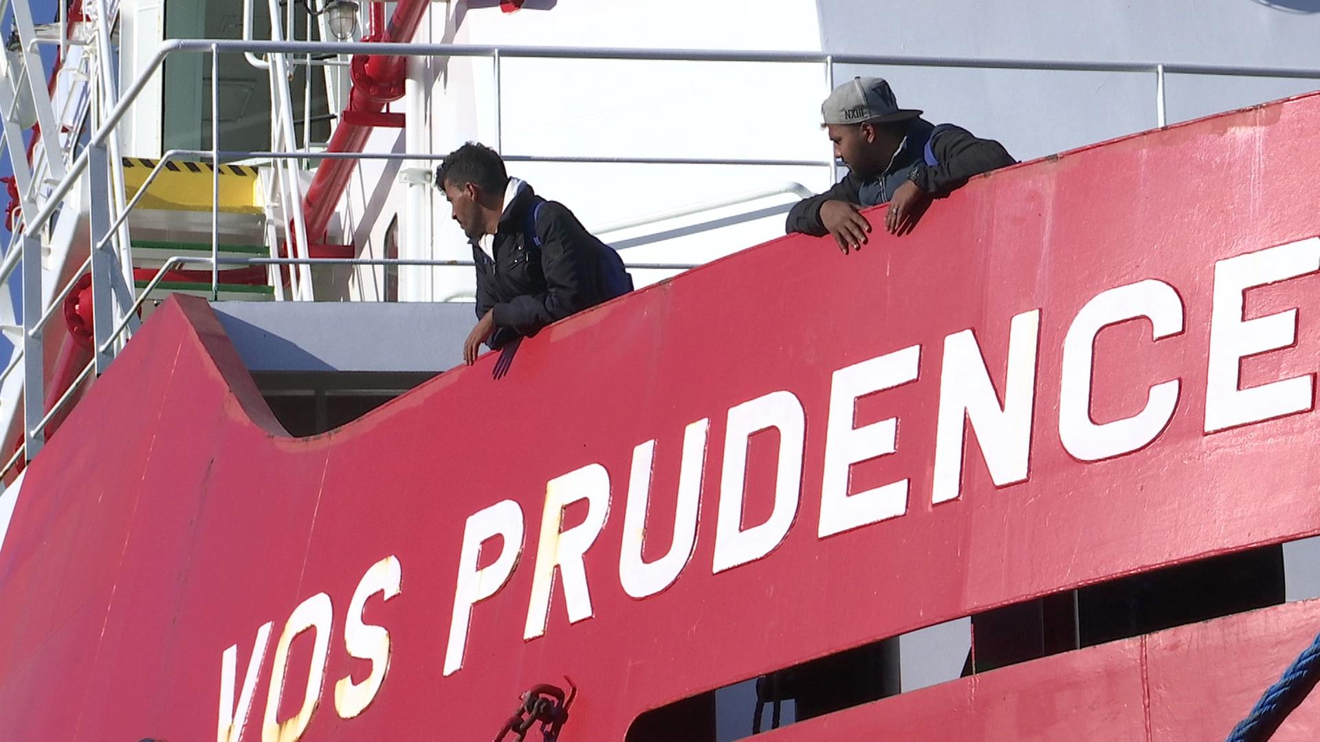 Zwei Flüchtlinge lehnen über den Rand des Rettungsschiffs "Prudence" der Organisation Ärzte ohne Grenzen Zwei Flüchtlinge lehnen über den Rand des Rettungsschiffs "Prudence" der Organisation Ärzte ohne Grenzen