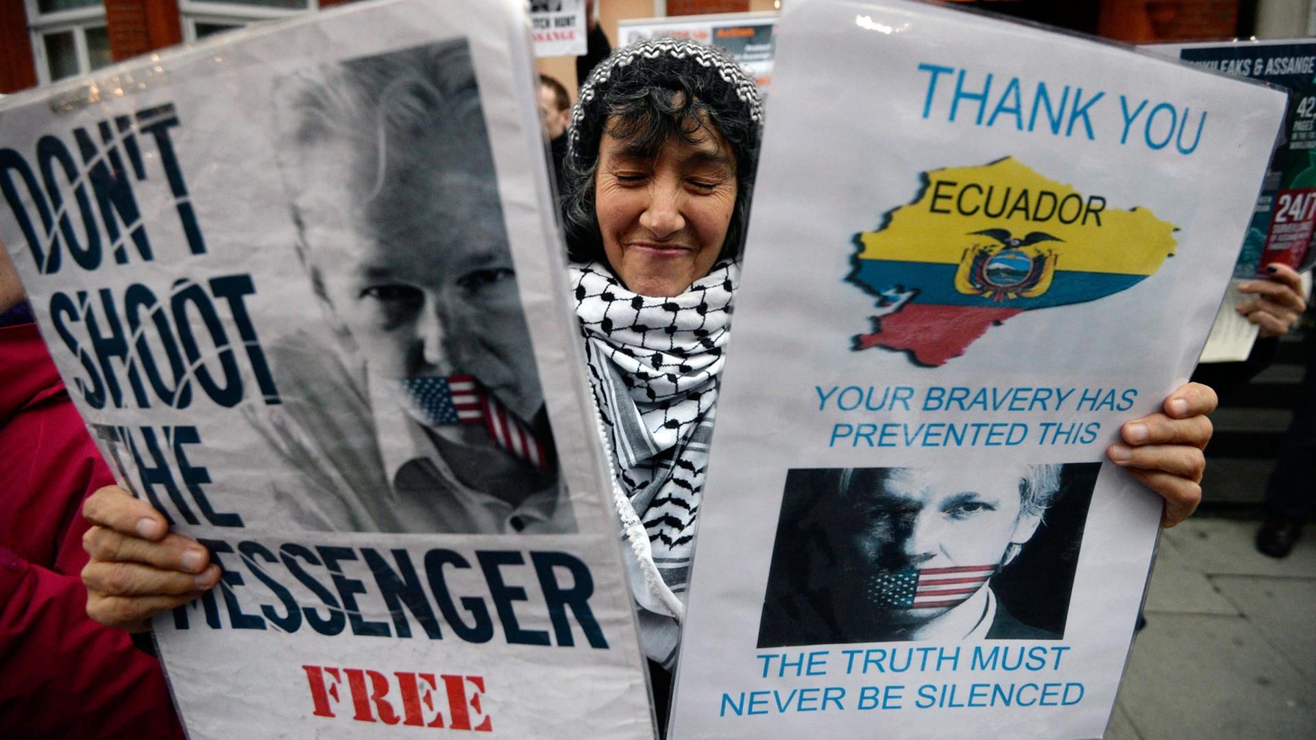 Eine Unterstützerin von Julian Assange hält Plakate hoch vor der ecuadorianischen Botschaft in London. Eine Unterstützerin von Julian Assange hält Plakate hoch vor der ecuadorianischen Botschaft in London.