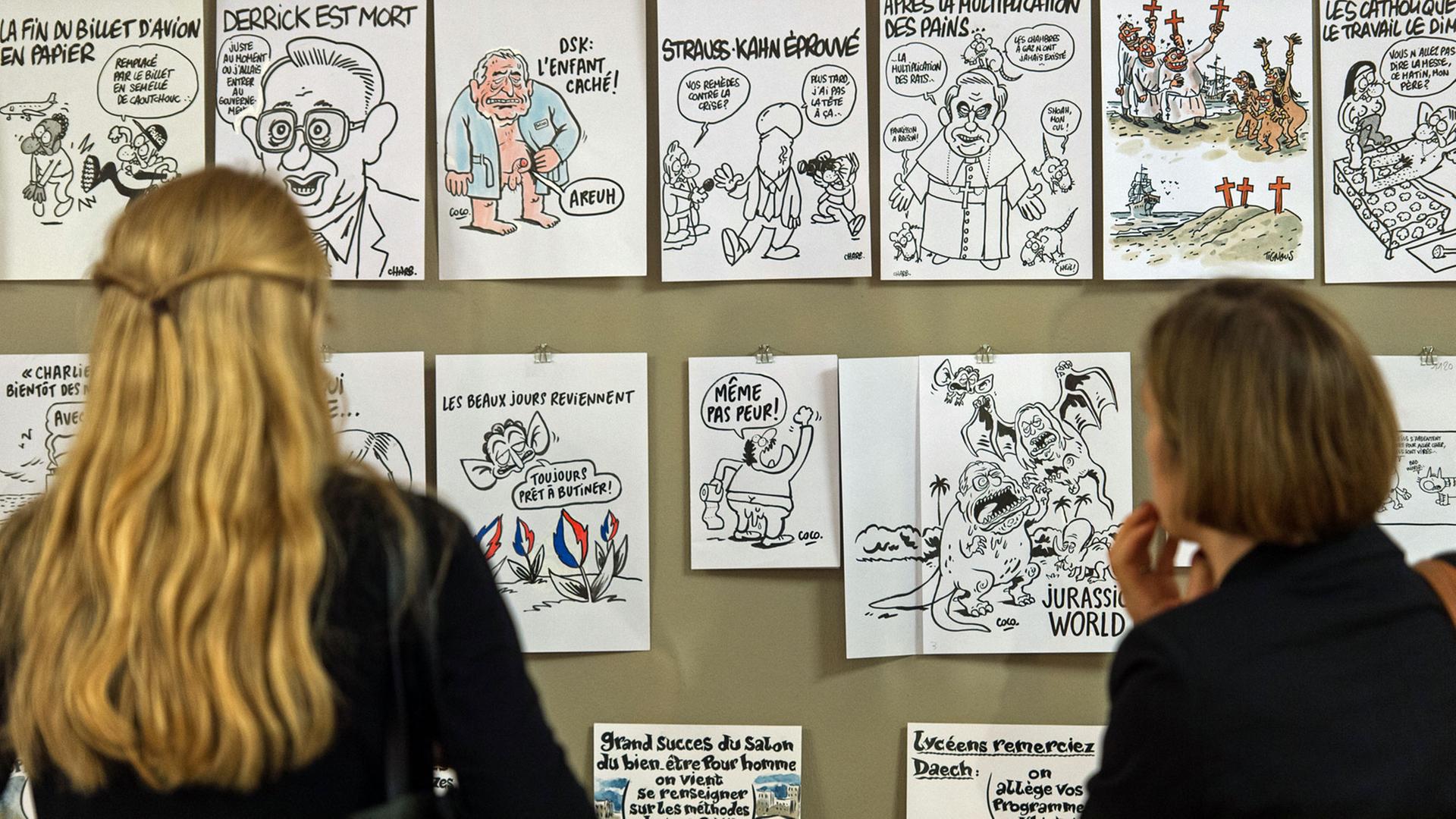 Zwei Frauen schauen sich am 08.07.2016 während einer Pressekonferenz zur Ausstellungseröffnung von "Caricatures. Spott und Humor in Frankreich von 1700 bis in die Gegenwart" im Wilhelm Busch Deutsches Museum für Karikatur und Zeichenkunst in Hannover (Niedersachsen) Karikaturen von Künstlern der Zeitschrift "Charlie Hebdo" an. Die Ausstellung ist vom 09. Juli bis 06. September zu sehen und zeigt die Geschichte der französischen Karikatur bis "Charlie Hebdo". Zwei Frauen schauen sich am 08.07.2016 während einer Pressekonferenz zur Ausstellungseröffnung von "Caricatures. Spott und Humor in Frankreich von 1700 bis in die Gegenwart" im Wilhelm Busch Deutsches Museum für Karikatur und Zeichenkunst in Hannover (Niedersachsen) Karikaturen von Künstlern der Zeitschrift "Charlie Hebdo" an. Die Ausstellung ist vom 09. Juli bis 06. September zu sehen und zeigt die Geschichte der französischen Karikatur bis "Charlie Hebdo".
