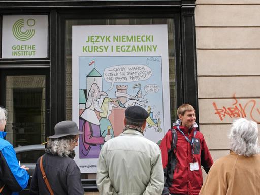 Reisefuehrer mit einer Besuchergruppe vor dem Goethe - Institut in der Altstadt von Krakau in Polen, das fuer Kurse in deutscher Sprache wirbt, aufgenommen am 28.5.2015. Foto: Rainer Oettel | Verwendung weltweit