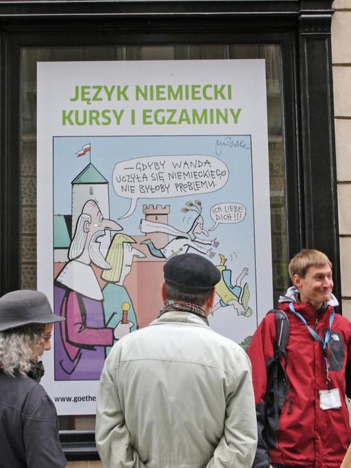 Reisefuehrer mit einer Besuchergruppe vor dem Goethe - Institut in der Altstadt von Krakau in Polen, das fuer Kurse in deutscher Sprache wirbt, aufgenommen am 28.5.2015. Foto: Rainer Oettel | Verwendung weltweit