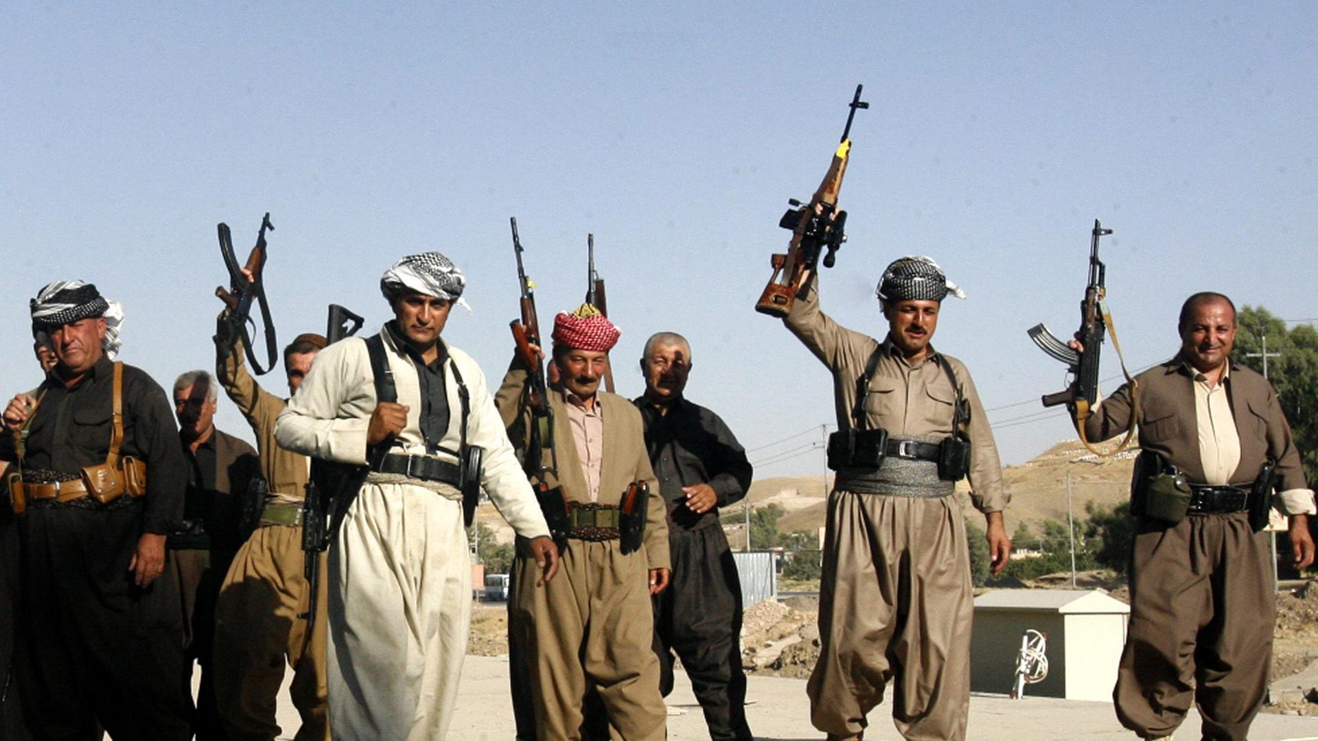 Kämpfer, die gemeinsam mit kurdischen Kräften gegen die IS kämpfen, halten ihre Waffen hoch. Kämpfer, die gemeinsam mit kurdischen Kräften gegen die IS kämpfen, halten ihre Waffen hoch.