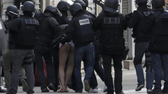 Französische Polizisten führen im Pariser Vorort Saint Denis einen Verdächtigen ab.