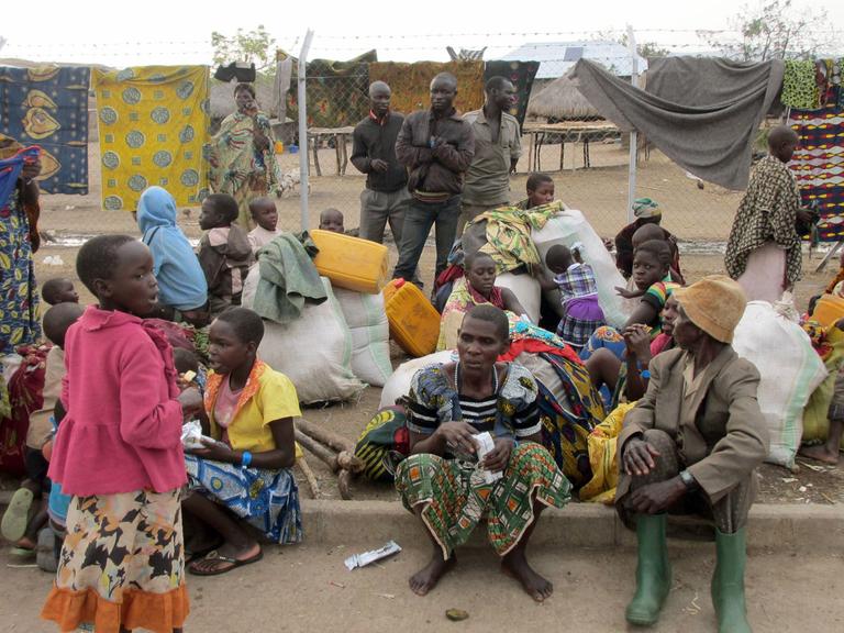 Aus dem Kongo kommende Flüchtlinge sitzen am 06.03.2018 im ugandischen Sebagoro auf dem Boden.