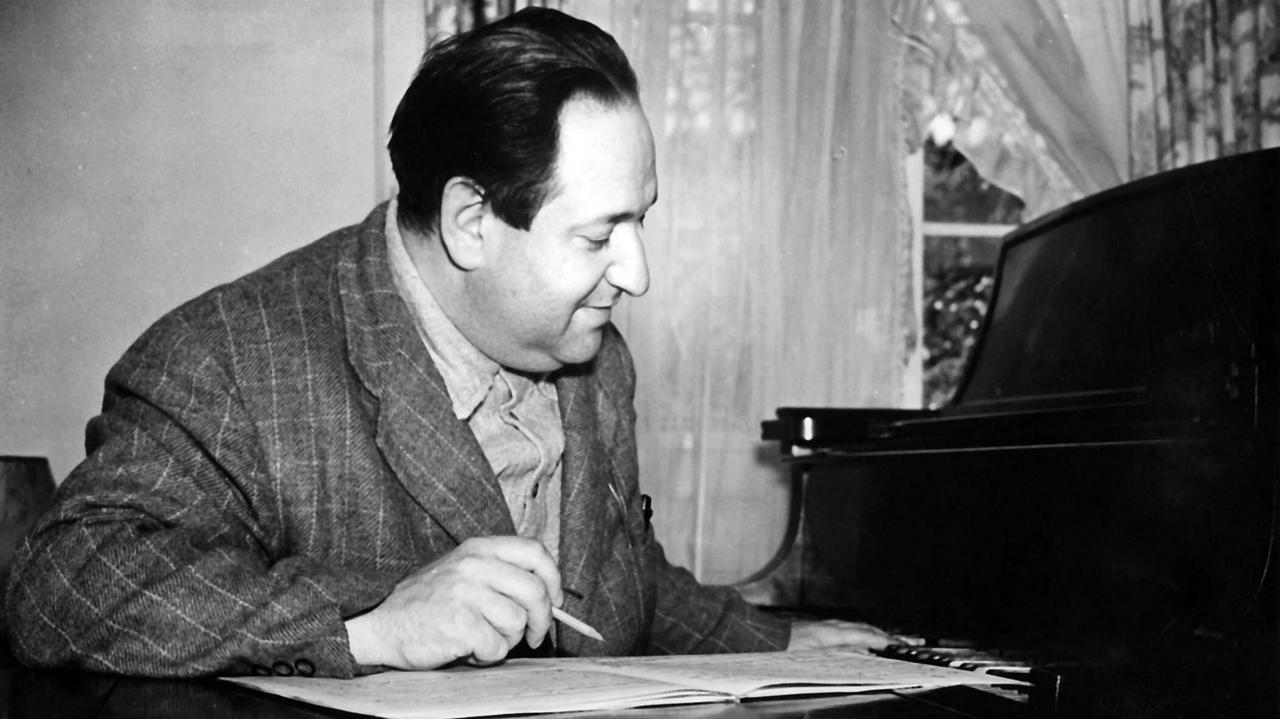 Erich Wolfgang Korngold 1936 an seinem Schreibtisch arbeitend.