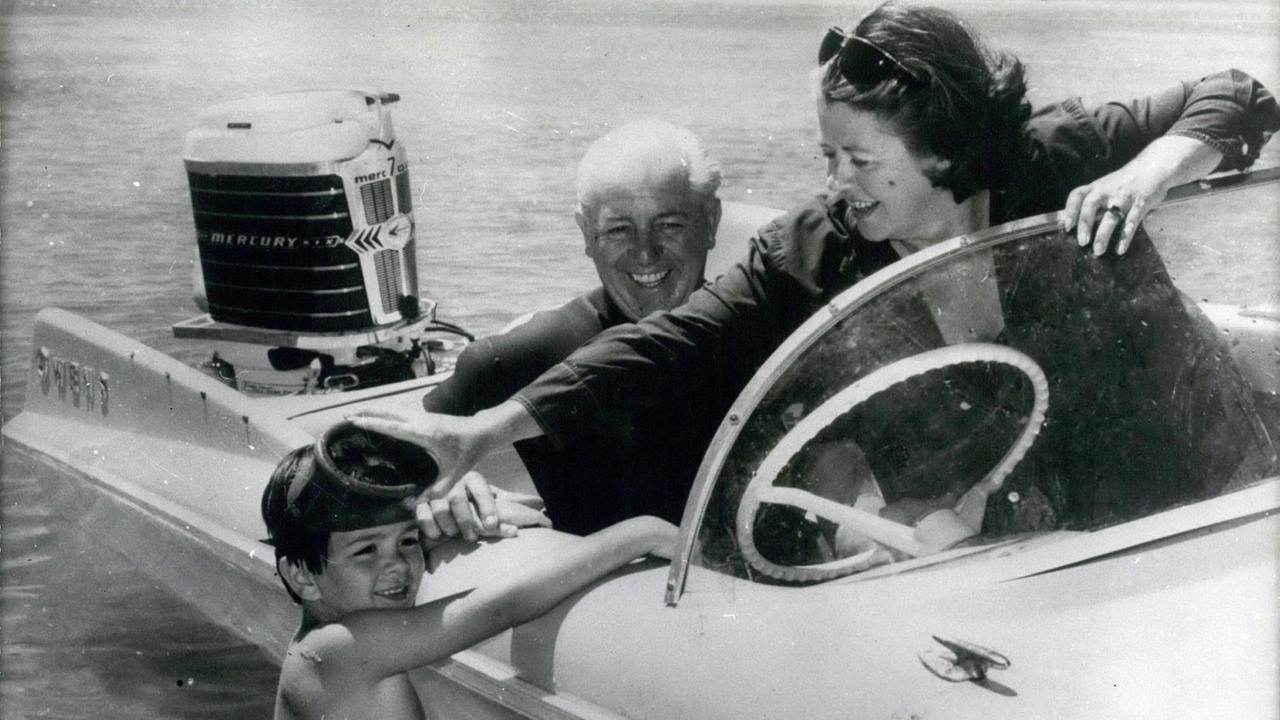 Schwarz-Weiß-Aufnahme des früheren australischen Premierministers Harold Holt mit seiner Frau und seinem Enkelsohn in einem Boot am Strand von Portsea in Australien Schwarz-Weiß-Aufnahme des früheren australischen Premierministers Harold Holt mit seiner Frau und seinem Enkelsohn in einem Boot am Strand von Portsea in Australien
