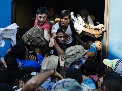 Flüchtlinge versuchen im Bahnhof von Gevgelija in Mazedonien in einen Zug zu gelangen.