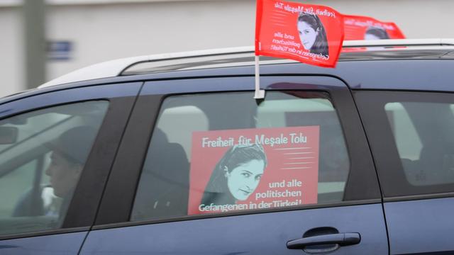 Ein Mann demonstriert für die Freiheit von Mesale Tolu und allen politischen Gefangenen in der Türkei in Frankfurt am Main (Hessen) mit Fahnen an seinem Auto.